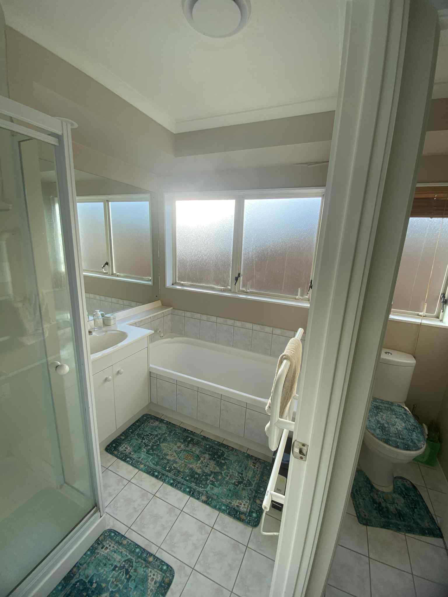Bathroom before renovation — dated tiles and fittings