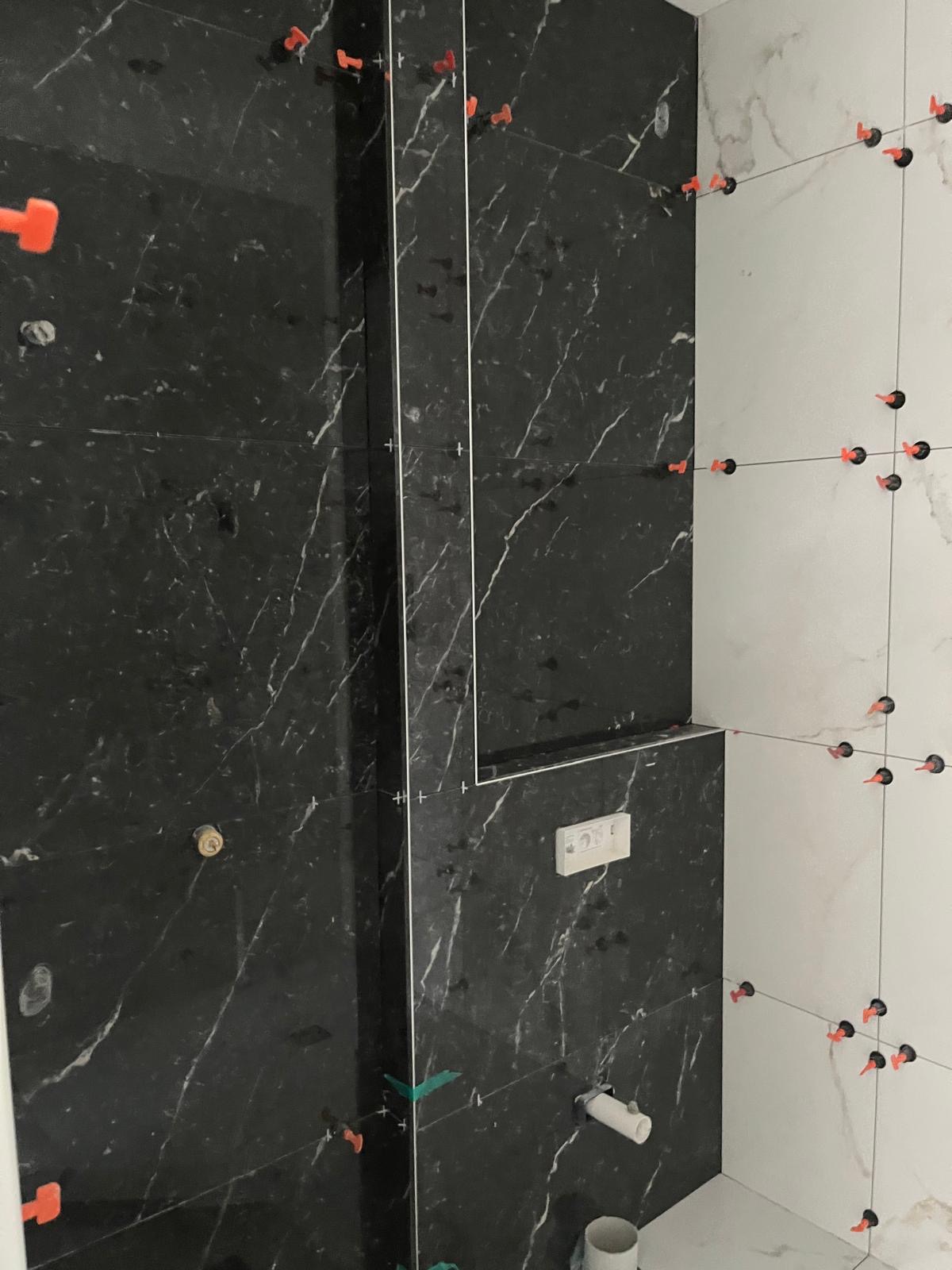 Plumbing rough-in with black and white marble tiling and niche